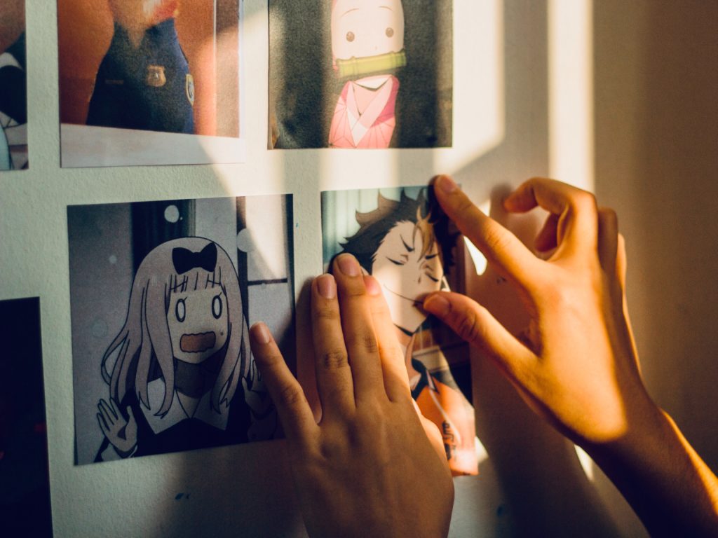 hands scribbling on the wall images of anime characters