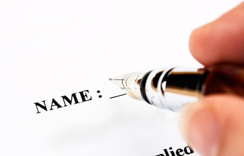 a fountain pen about to fill in the name section on a piece of paper