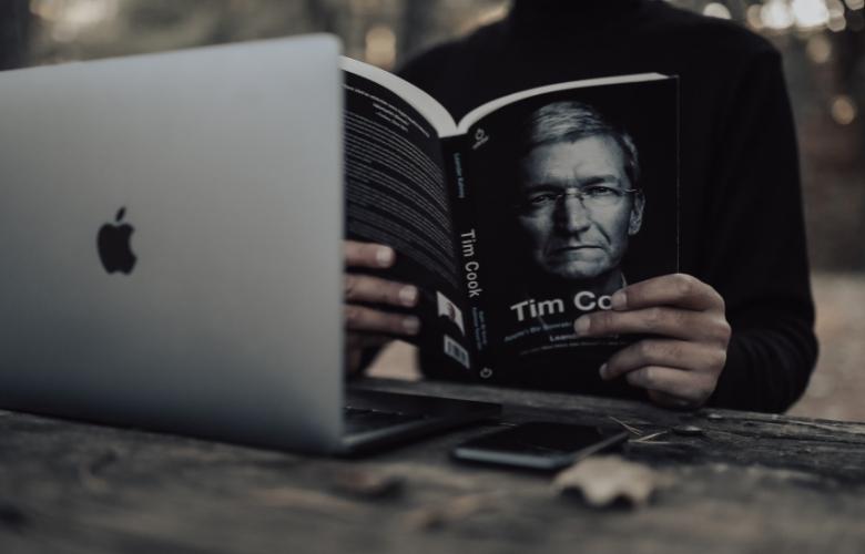 a man is reading tim cook's biography.