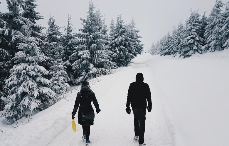 two persons in the middle of the road on a snowy setting