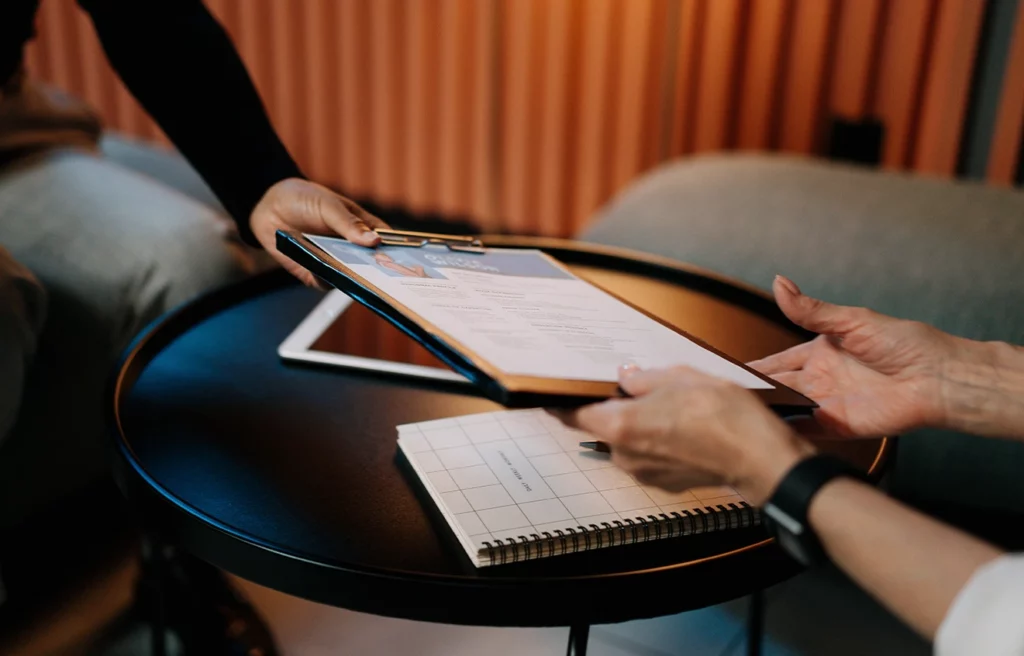 a woman handing her resume to her interviewer